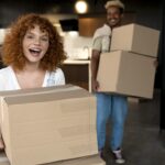 couple-handling-cardboard-boxes-with-belongings-after-moving-together-new-home