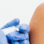 Free Flu Shots at Baptist DeSoto Drive-Thru Oct. 8 Close-up of a healthcare worker giving a vaccine, illustrating free flu shots at Baptist DeSoto