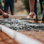Hernando Mixed-Use Developments Add Shops, Homes, YMCA Workers smoothing freshly poured concrete, illustrating construction at Hernando mixed-use developments