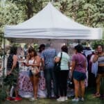 Hernando Water Tower Festival Sells Out, Brings Back Live Music Shoppers browse vendor booths at an outdoor market, similar to the Hernando Water Tower Festival