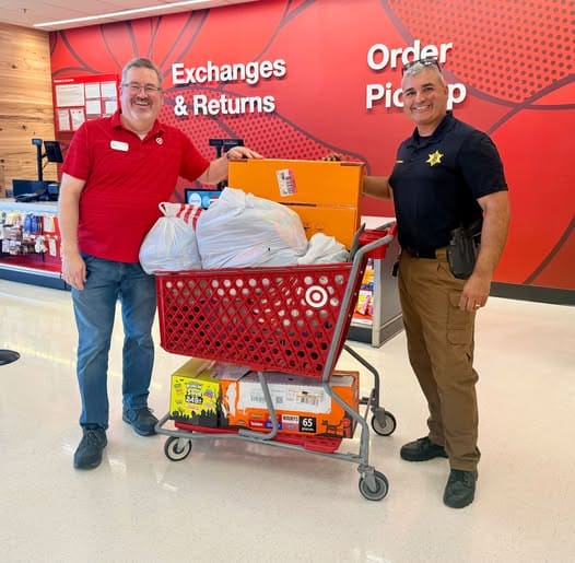Olive Branch Target manager and a DeSoto County sheriff's deputy with a cart of candy donated for the DeSoto Central Homecoming Parade