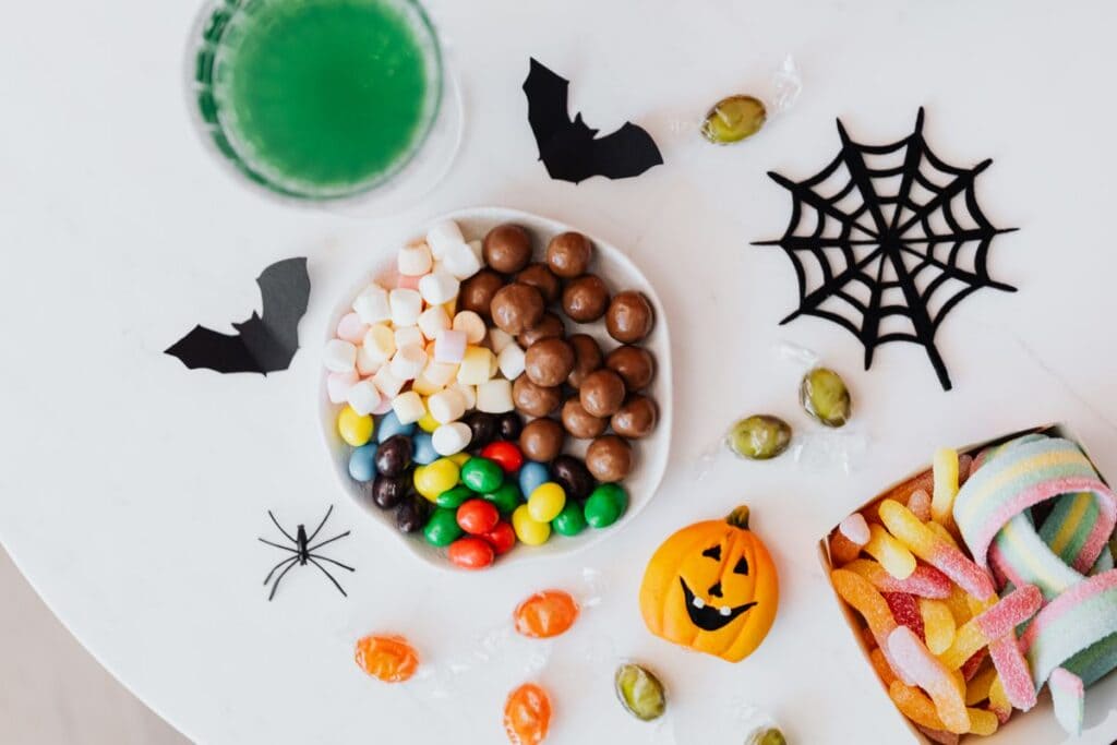 Festive Halloween candies and decorations arranged on a white table with a spooky theme — party-table ideas for DeSoto County celebrations.