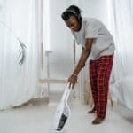The 5 Best Cordless Stick Vacuums for Busy DeSoto County Families A person vacuuming a bright home floor with a white cordless stick vacuum