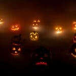 The 5 Best Pumpkin Carving Kits for DeSoto County Families Glowing carved jack-o'-lantern pumpkins arranged in a spooky nighttime Halloween display.