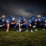 DeSoto County Football Scores: DeSoto Central Wins in OT Football team lined up under stadium lights, illustrating DeSoto County football scores