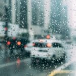 DeSoto County Rain Returns Friday After Hot, Dry Stretch Raindrops on a car window with traffic lights blurred behind, illustrating DeSoto County rain returning Friday