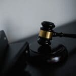 Judge Lets Henley Defamation Suit Against DeSoto DA Proceed Wooden judge's gavel beside a stack of legal folders, illustrating the Henley defamation suit