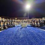 Olive Branch Band Named Marching Classic Grand Champions Olive Branch High School Marching Band members pose on the field at night with their trophies